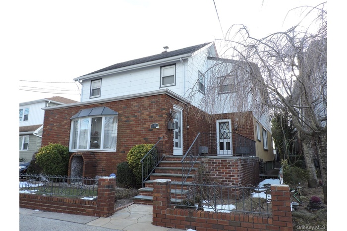 Traditional-style house featuring a fenced front yard and brick siding