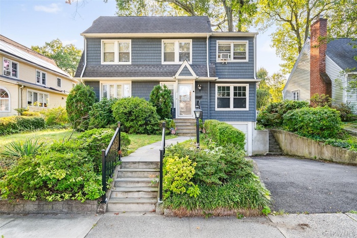 View of front facade featuring asphalt driveway