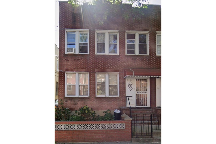 Traditional-style house featuring a fenced front yard and brick siding