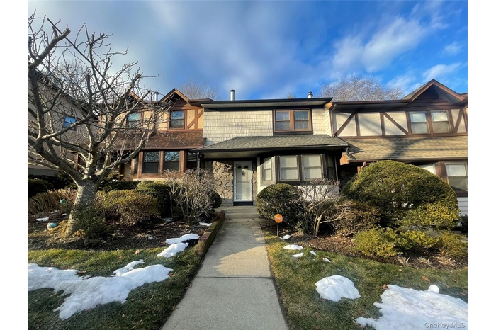Tudor home featuring stone siding and roof with shingles