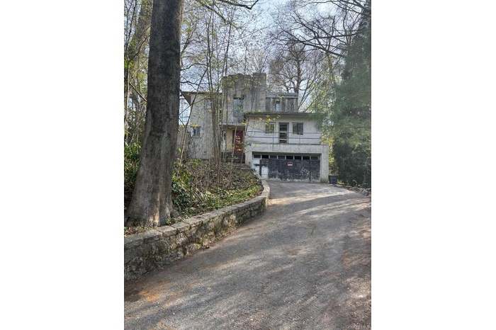 View of front facade featuring driveway and an attached garage