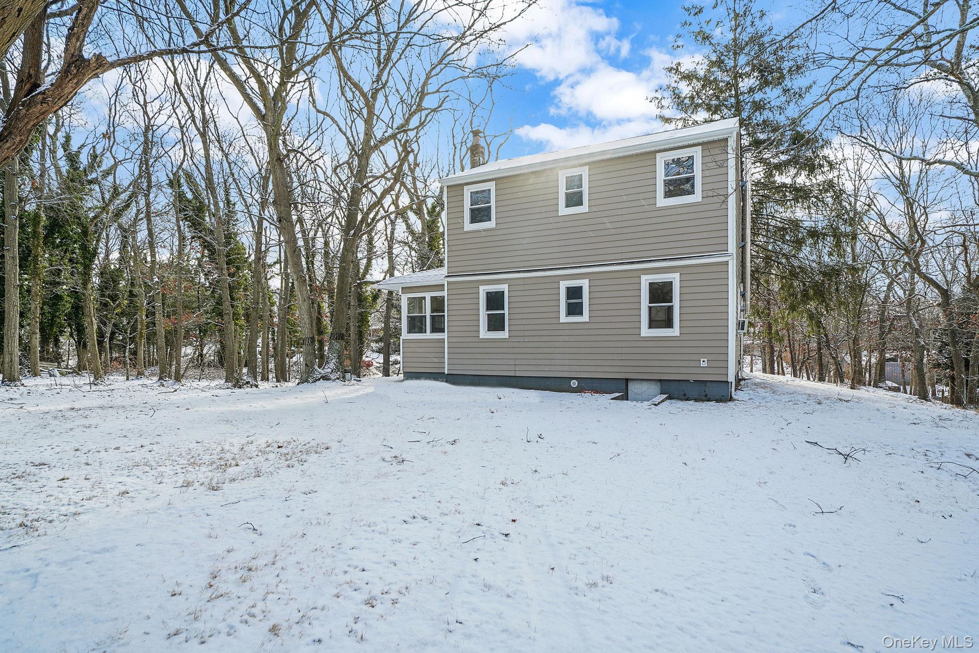 View of snow covered back of property