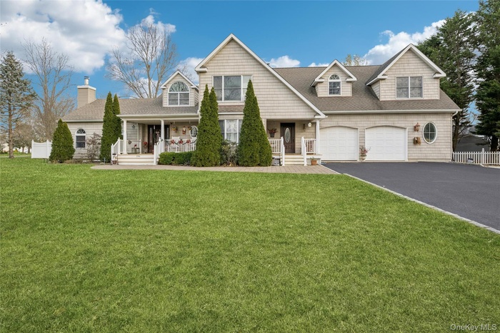 View of front of home with covered porch, asphalt driveway, roof with shingles, and a chimney