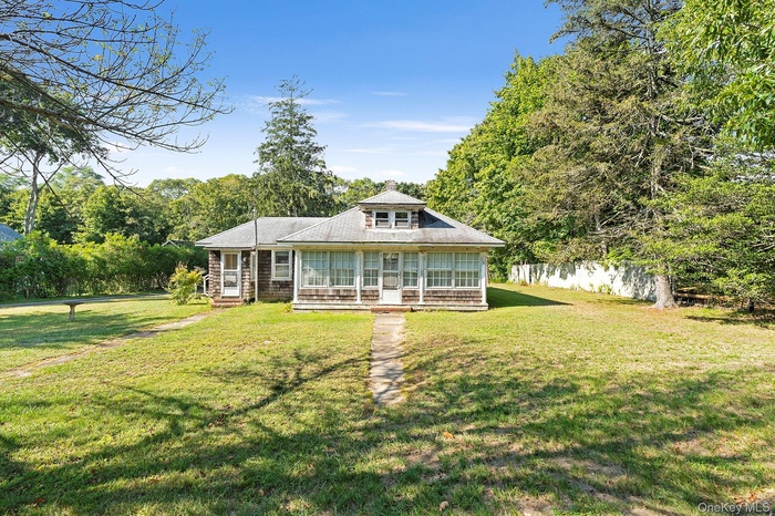 Back of house featuring a sunroom and a yard