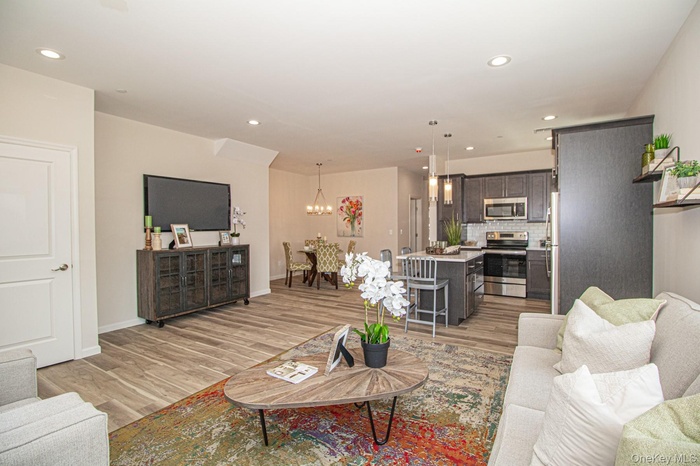 Living room with recessed lighting, light wood finished floors, and a chandelier