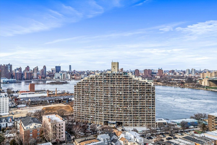 View of city skyline featuring a nearby body of water and a notable bridge