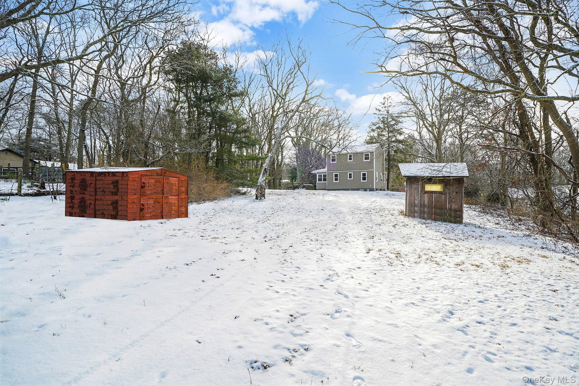 Yard covered in snow with a storage shed
