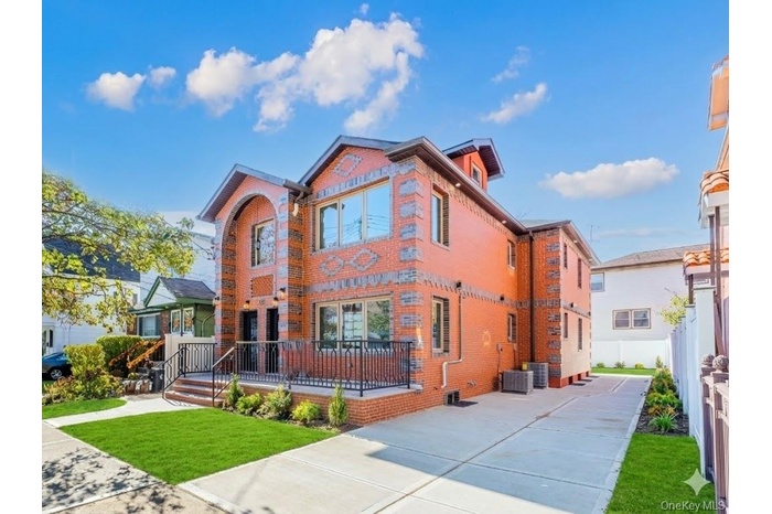 View of front of home with brick siding and a front yard