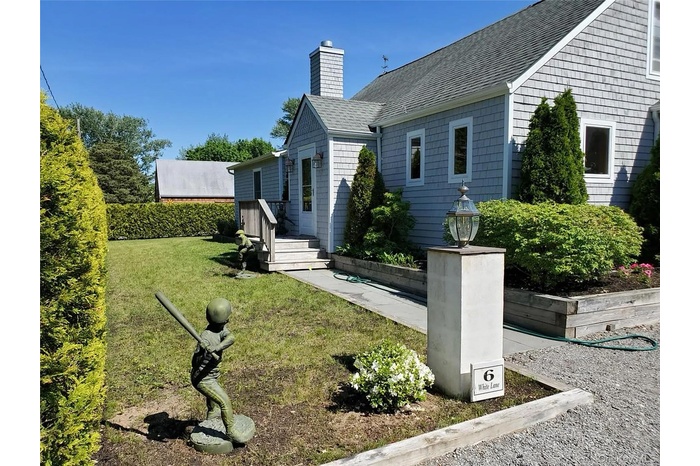 View of home's exterior featuring a lawn, a shingled roof, and a chimney