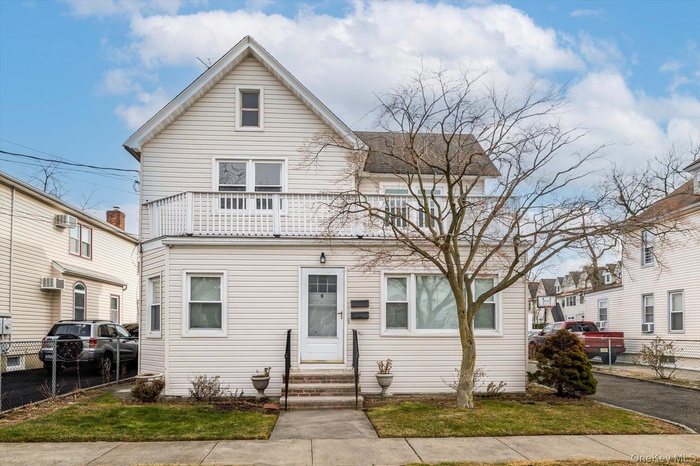 View of front facade with entry steps and a balcony
