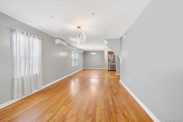 Spare room featuring light wood finished floors and an AC wall unit