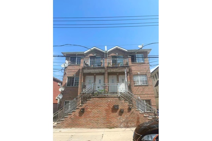 Traditional home featuring stairway, brick siding, and a balcony