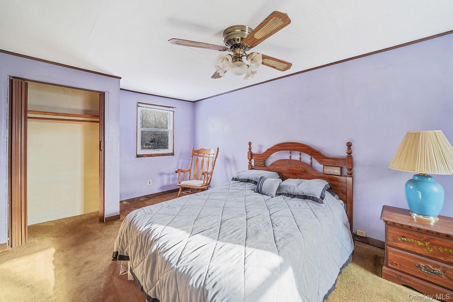 Bedroom featuring crown molding, carpet floors, a closet, and a ceiling fan