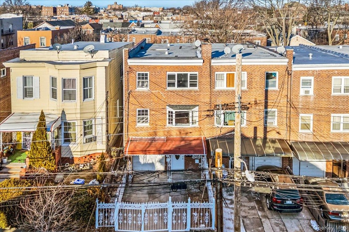 Rear view of house with a fenced front yard, brick siding, and a residential view