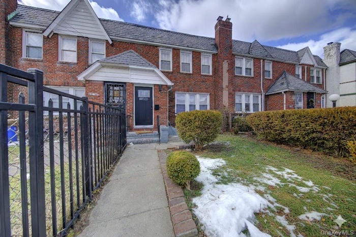 View of front facade with brick siding and a chimney