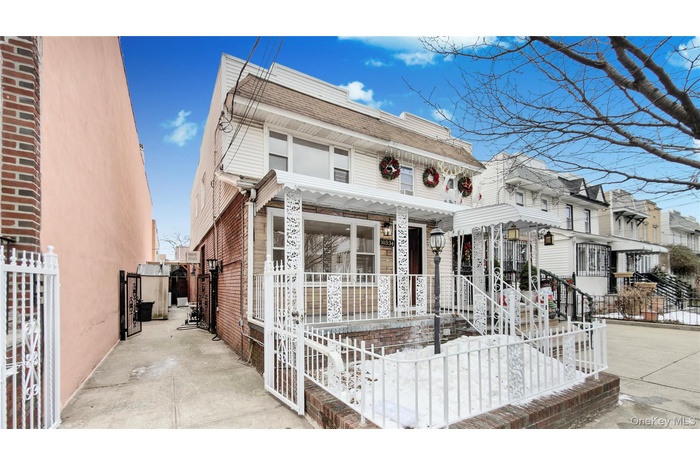 View of front facade with covered porch, a residential view, and mansard roof