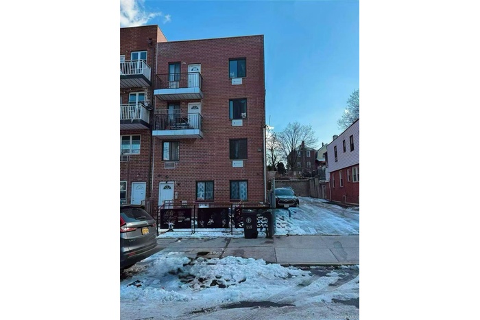 Snow covered building with a view of apartment building / complex