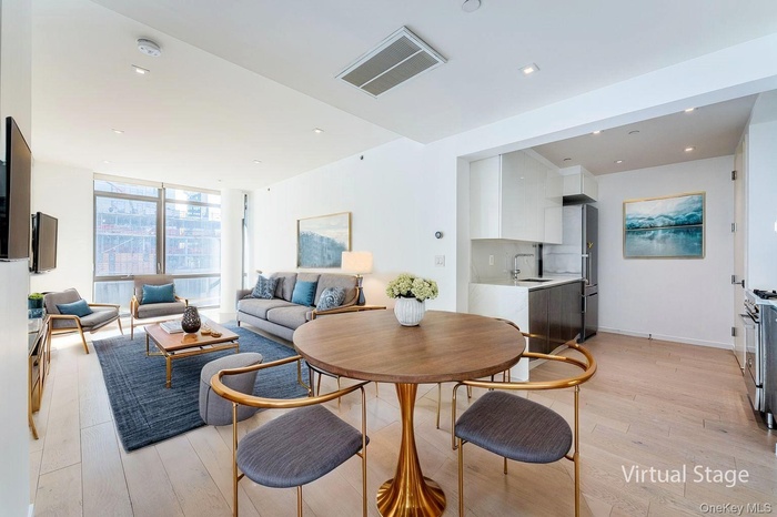 Dining area with a wall of windows, light wood-style flooring, and recessed lighting
