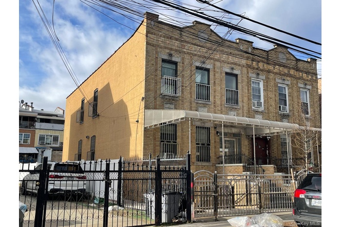 View of front of property with a fenced front yard, brick siding, and a gate
