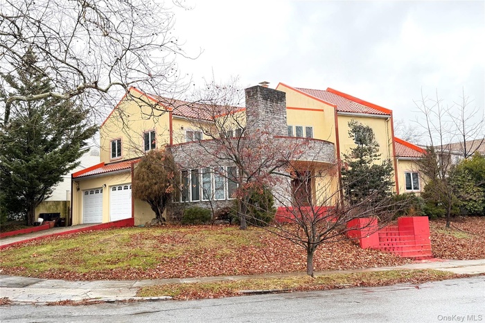 Mediterranean / spanish home with a tiled roof, a chimney, driveway, and an attached garage