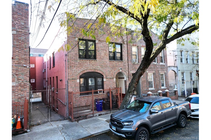View of front of property featuring a gate, a fenced front yard, and brick siding