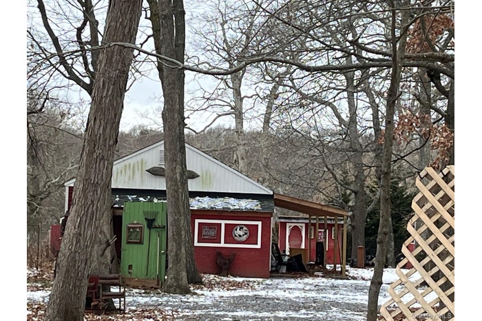 View of snowy exterior featuring an outdoor structure and an outbuilding