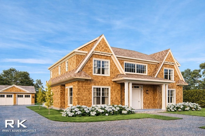 Shingle-style home featuring a shingled roof, a front lawn, a detached garage, and covered porch