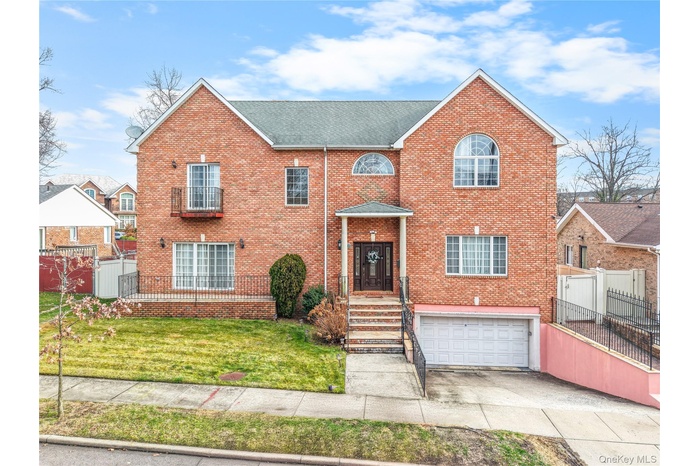 Colonial inspired home featuring brick siding, concrete driveway, and a garage