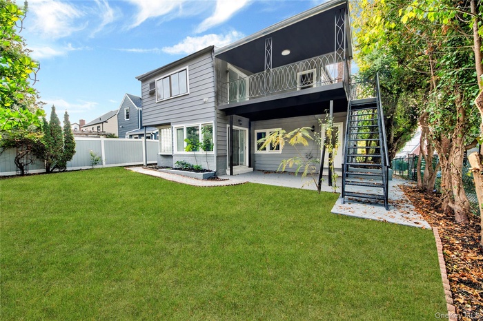 Rear view of house with a patio, a fenced backyard, and stairway