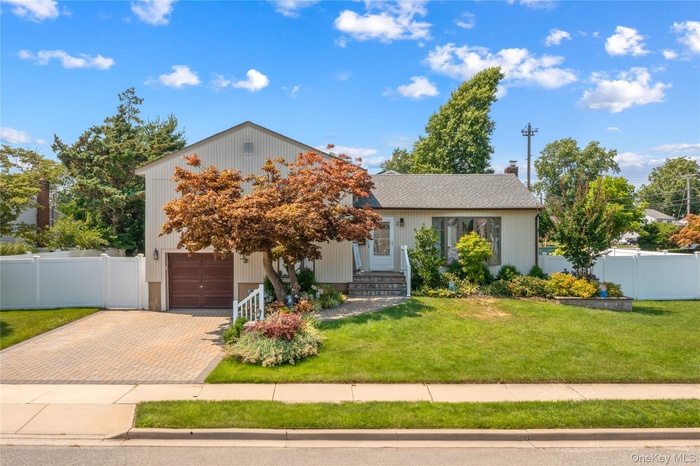View of front facade featuring decorative driveway and a garage