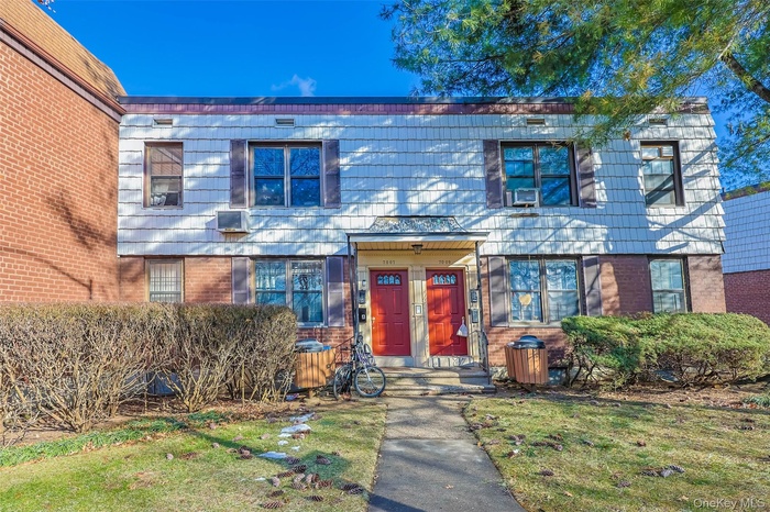 Colonial house with brick siding and a front lawn