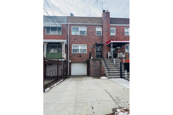 Traditional-style house featuring brick siding, a shingled roof, and driveway