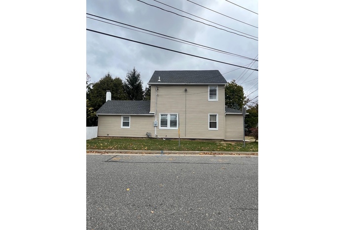 View of home's exterior featuring a shingled roof and a chimney