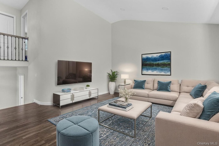 Living room with wood finished floors and high vaulted ceiling