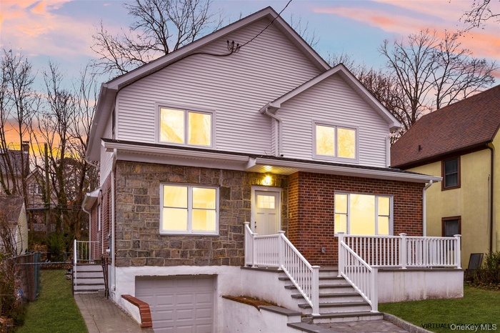 View of front of house featuring stone siding and an attached garage