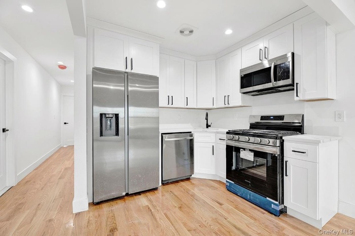 Kitchen featuring appliances with stainless steel finishes, white cabinets, light wood finished floors, and recessed lighting