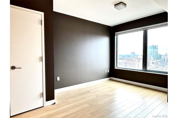Empty room featuring light wood-style flooring and a city view
