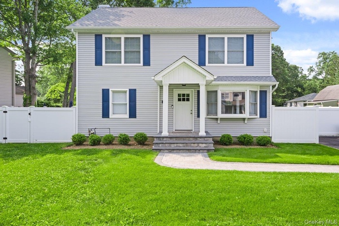 View of front of home with a gate and roof with shingles