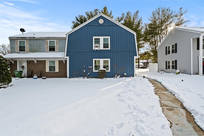 Snow covered back of property featuring board and batten siding