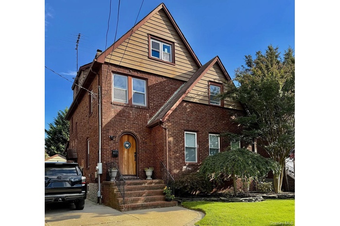 View of front of house featuring brick siding and a front lawn
