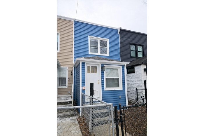 View of front facade featuring a gate and a fenced front yard