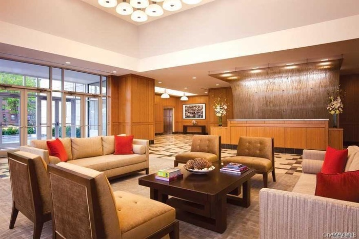 Building lobby with wooden walls, a high ceiling, and recessed lighting