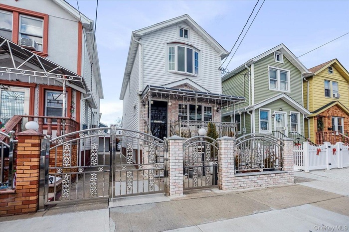 View of front facade featuring a gate, a fenced front yard, and brick siding