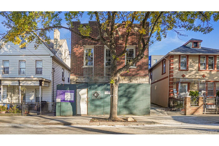 View of front facade featuring a fenced front yard, brick siding, and a gate