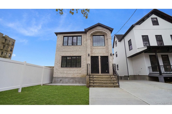 View of front facade with brick siding and a front yard