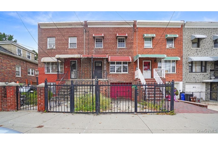 Traditional home featuring brick siding, a fenced front yard, and a gate