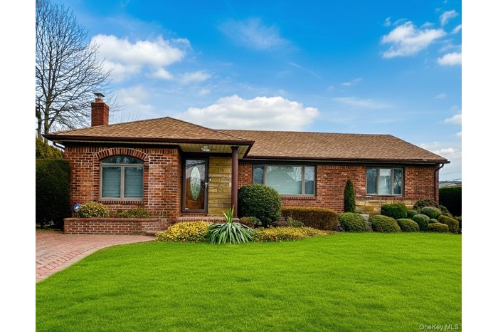 Ranch-style house featuring a front lawn, brick siding, and roof with shingles