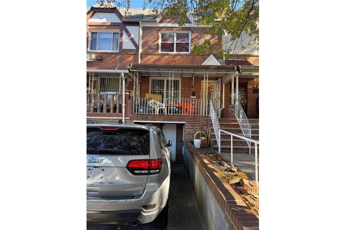 View of front of home featuring brick siding, a porch, and stairs