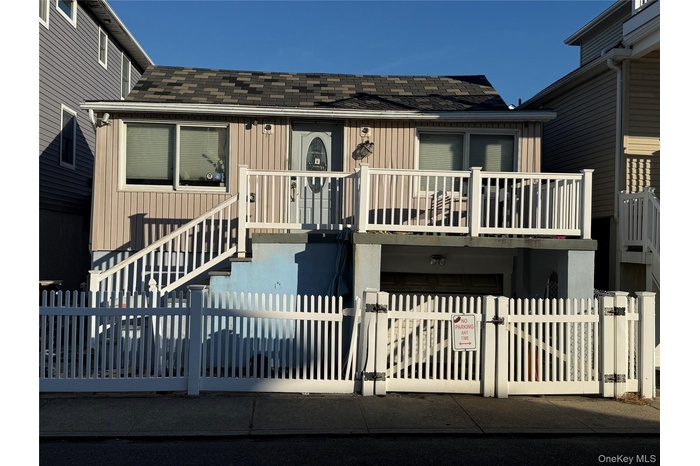 View of front of house featuring a gate, a shingled roof, and a fenced front yard