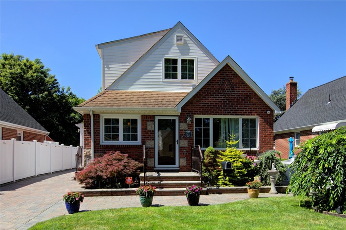View of front of property with brick siding and roof with shingles